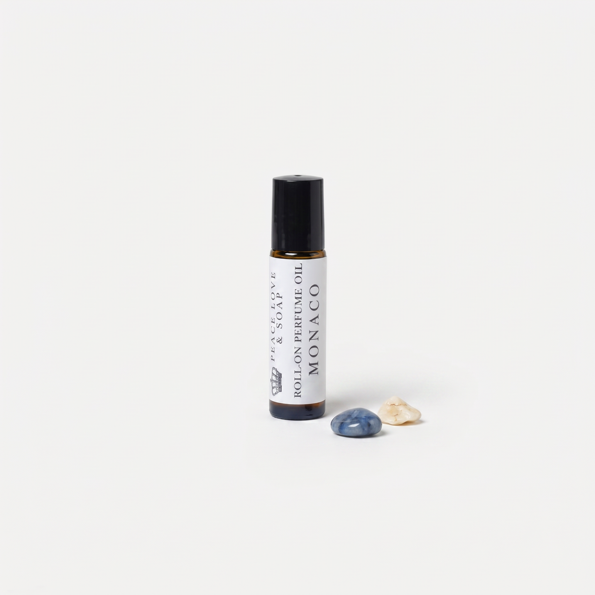 a small bottle of oil next to a small rock
