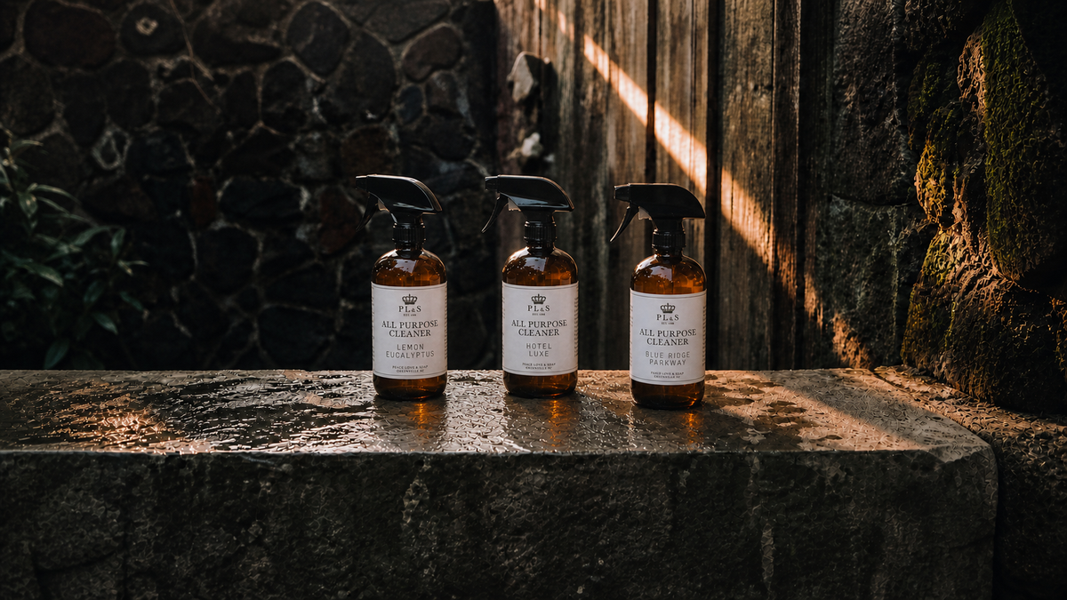 Peace Love & Soap All Purpose Cleaner collection featuring Lemon Eucalyptus, Hotel Luxe, and Blue Ridge Parkway in a moody garden setting