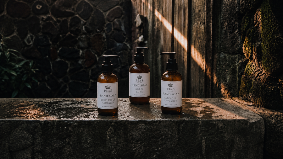 Peace Love & Soap Hand Soap collection featuring Blue Ridge Parkway, Hotel Luxe, and Patchouli Lavender in a moody garden setting