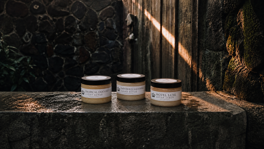 Peace Love & Soap Sugar Scrubs collection featuring Tropical Coconut, Patchouli Lavender, and Hotel Luxe in a moody garden setting