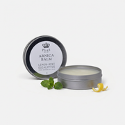 a round container with a white label next to a green leaf