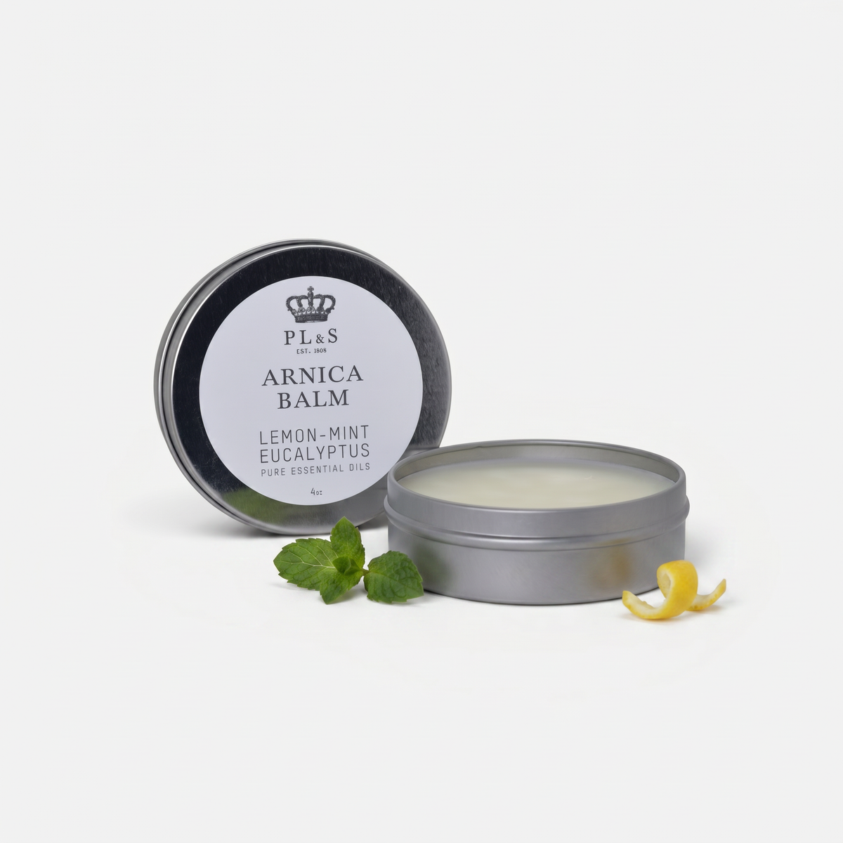 a round container with a white label next to a green leaf