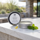 a round container with a label on it next to a leaf