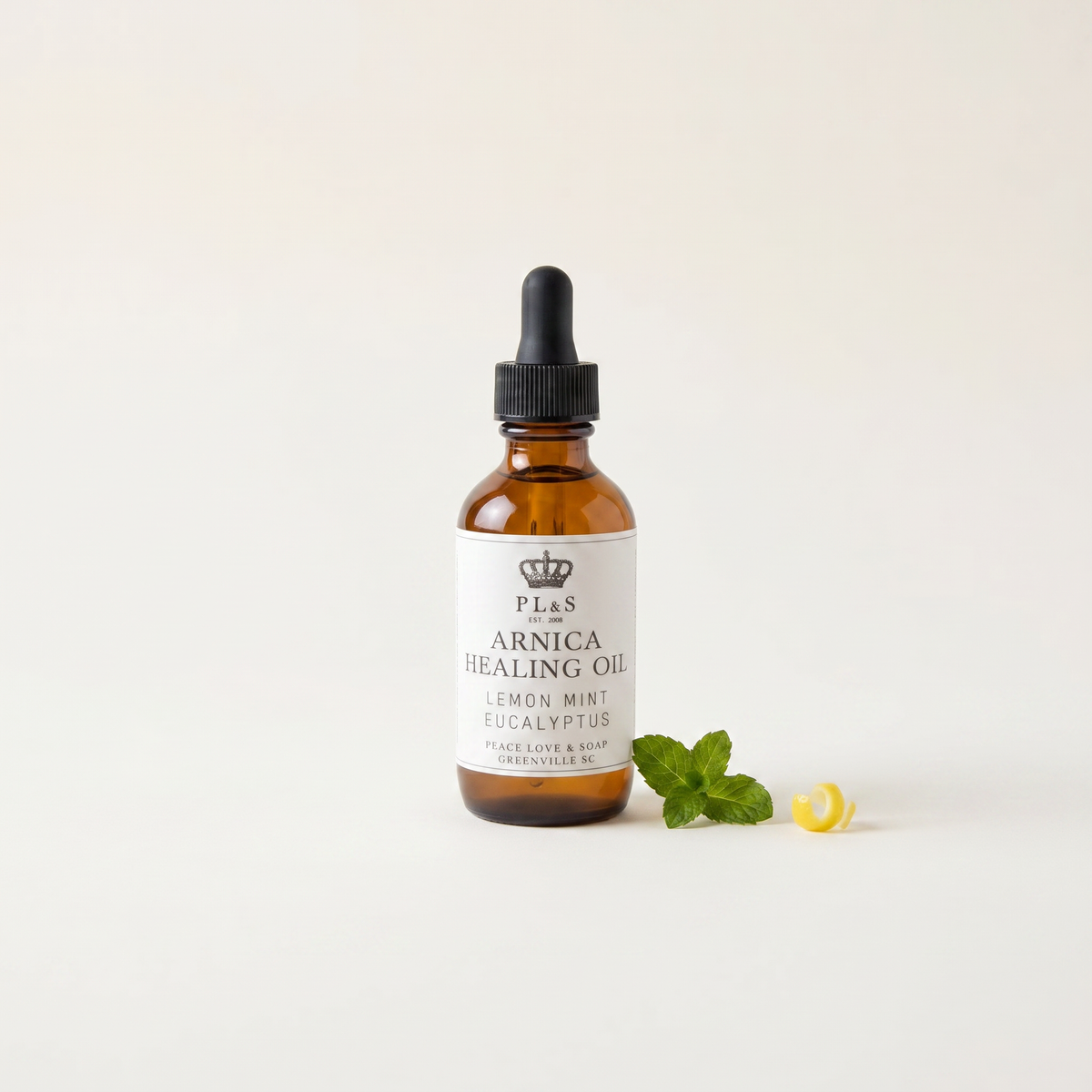 a bottle of essential oil next to a leaf