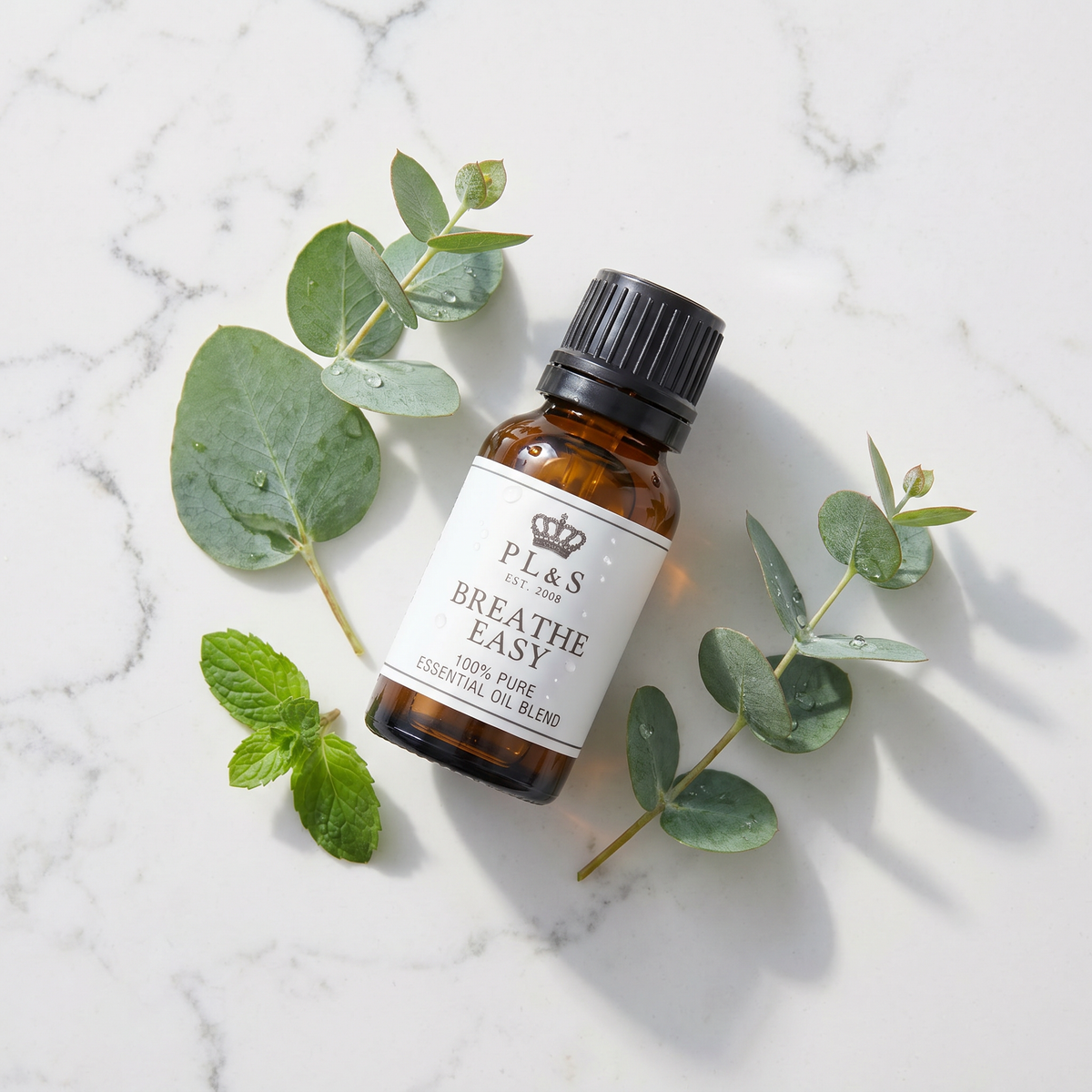 a bottle of essential oil next to leaves