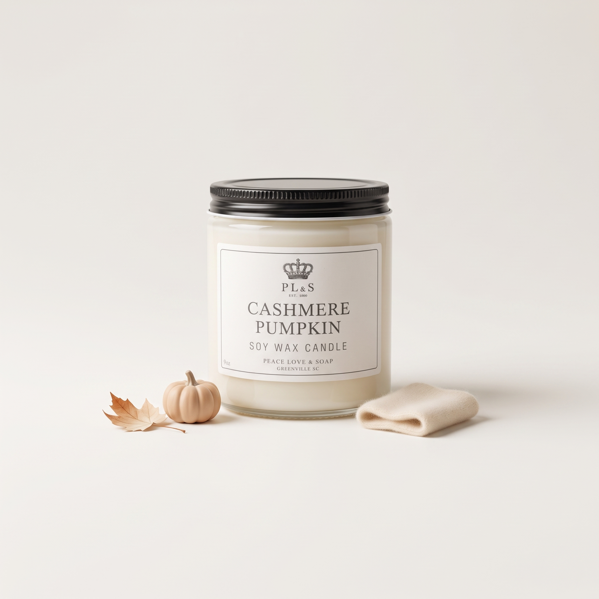 a jar of white candle next to a small pumpkin