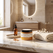 a bathroom counter with a towel and a jar of body butter