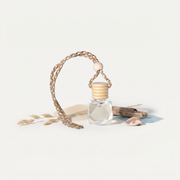 a small bottle of oil with a rope and a shell