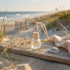 a bottle of perfume on a wood surface with a towel and wheat on the beach