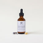 a bottle of face serum with a dropper and lavender