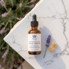 a bottle of face serum next to a flower