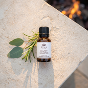 a small bottle of essential oil with a plant on a stone surface