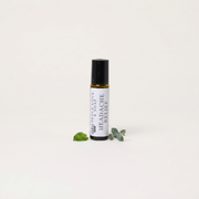 a small bottle of essential oil with leaves