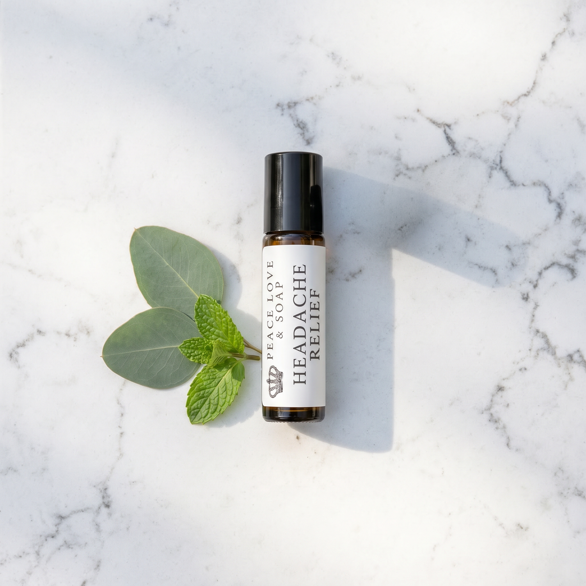 a small bottle of essential oil next to a leaf