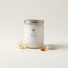 a white candle with a silver lid and a flower next to it