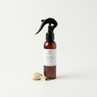 a bottle of spray with a black sprayer and a white flower