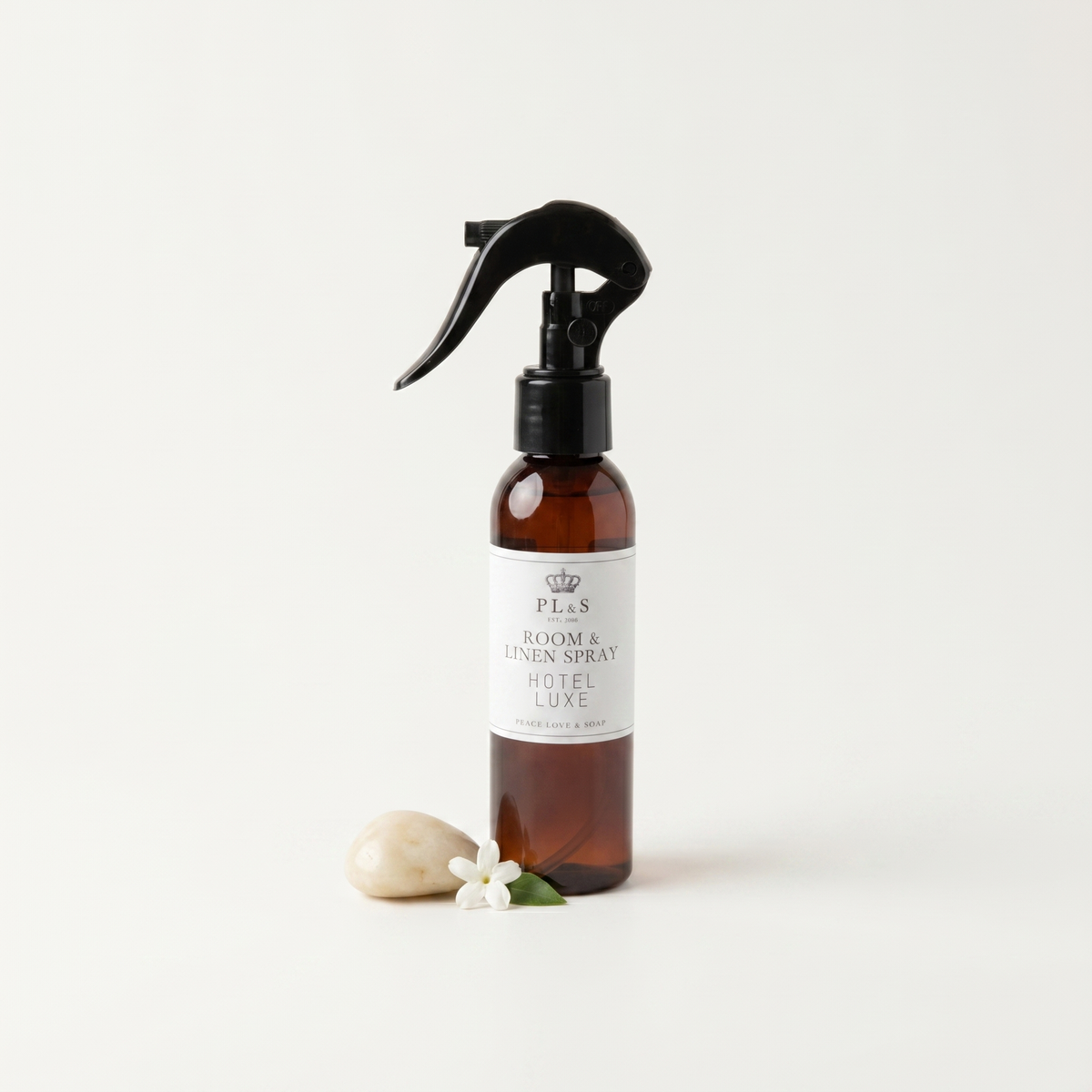 a bottle of spray with a black sprayer and a white flower