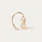 a small bottle of perfume with a white flower on a string