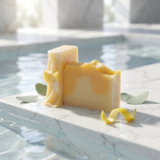 a block of cheese on a marble surface with water