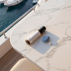 a bottle of essential oil and a rock on a table