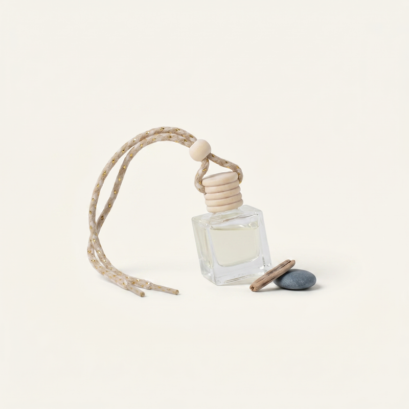 a small bottle of perfume with a string and a small stone