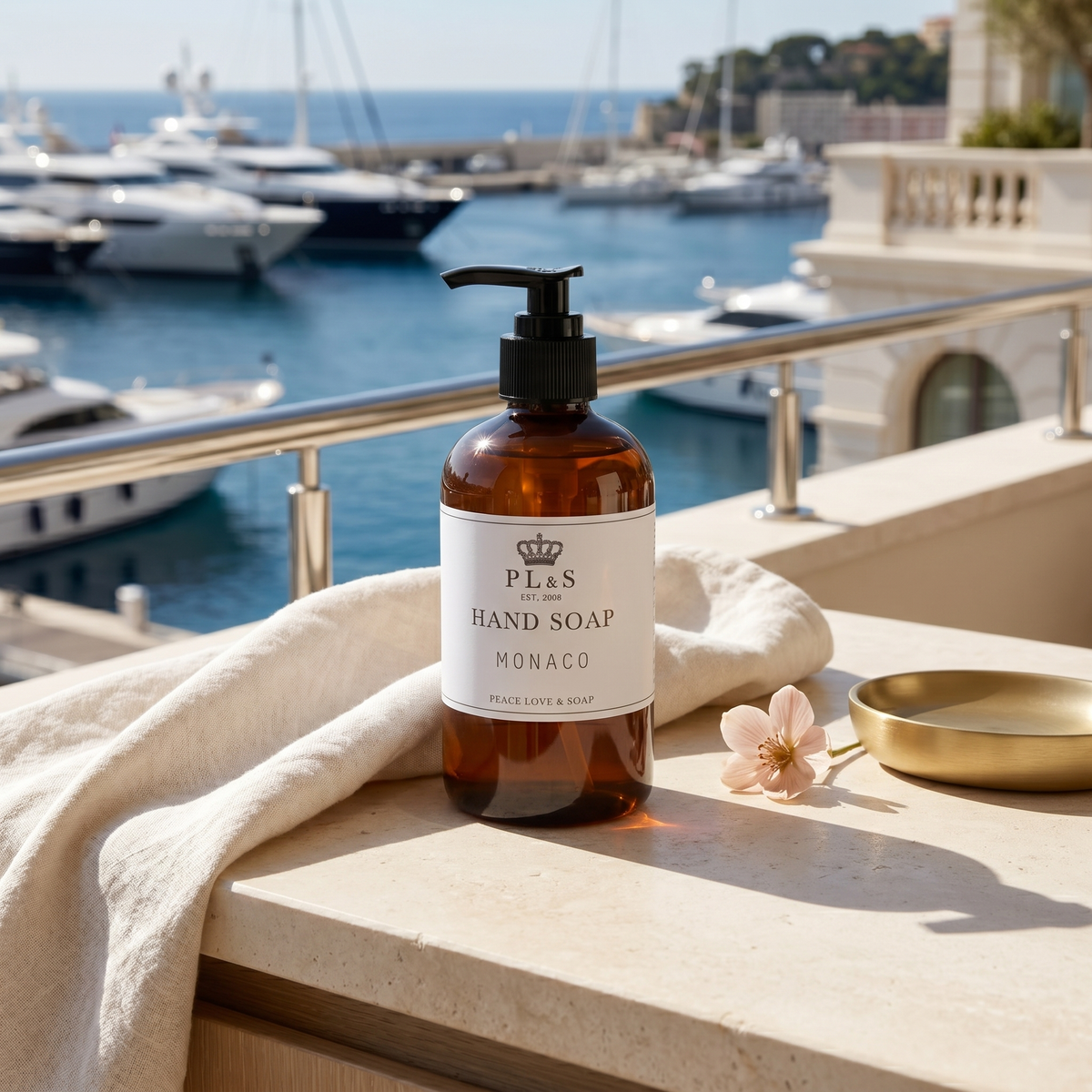 a bottle of soap on a ledge with a towel and a flower