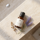 a small bottle of essential oil and lavender flowers