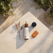 a bottle of essential oil and a wooden bar on a stone surface