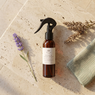 a spray bottle next to a towel and lavender
