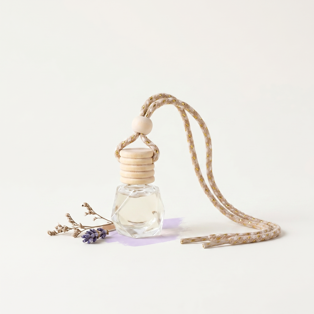 a small glass bottle with a string and a small flower