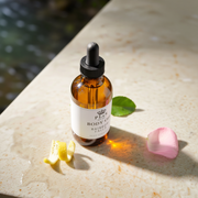 a bottle of body oil next to a lemon slice