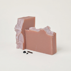 a pink soap with a broken piece
