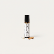 a small bottle of essential oil next to a small wooden object