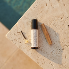 a small bottle of essential oil next to a stick